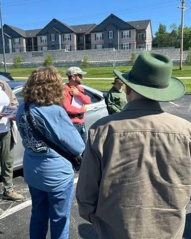 A group gathered in a car park at the start of a field trip.