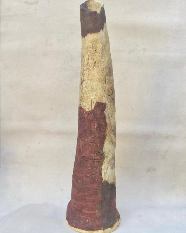 A tall tapering ceramic vessel in cream, rust, and brown, by Shoshana Parry.