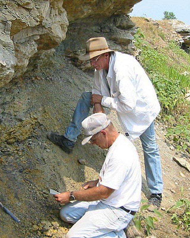 Barry Sutton standing at a shale outcrop while a second collector works the exposure below him.