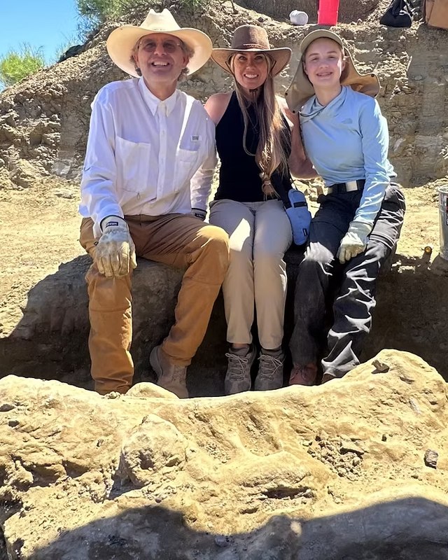 John Tosi, at left, with two others seated in a quarry beside an excavated block.