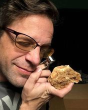 Asa Kaplan examining a fossil with a loupe.